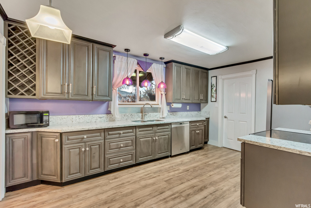 Kitchen featuring dishwasher, sink, crown molding, pendant lighting, and light hardwood / wood-style flooring