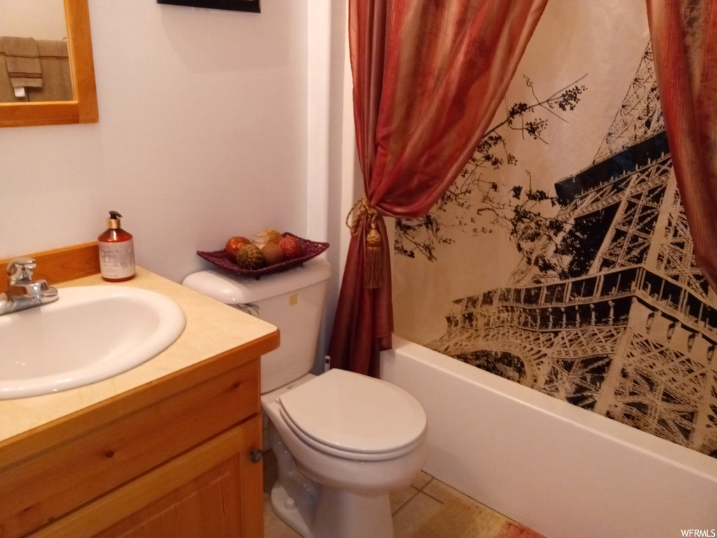 Full bathroom featuring toilet, tile flooring, shower / bath combo, and vanity