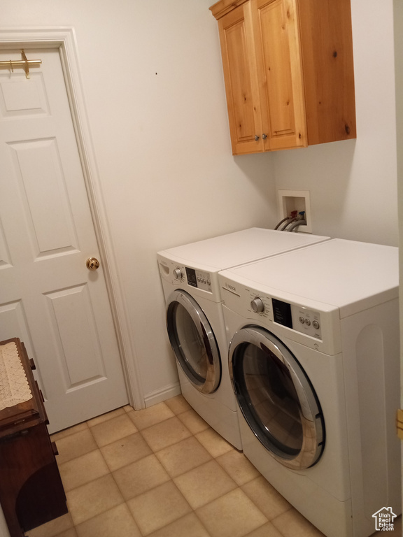 Laundry room featuring cabinets, light tile flooring, independent washer and dryer, and hookup for a washing machine