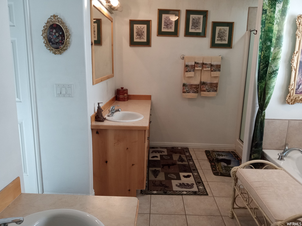 Bathroom with tile flooring, oversized vanity, and a bathing tub