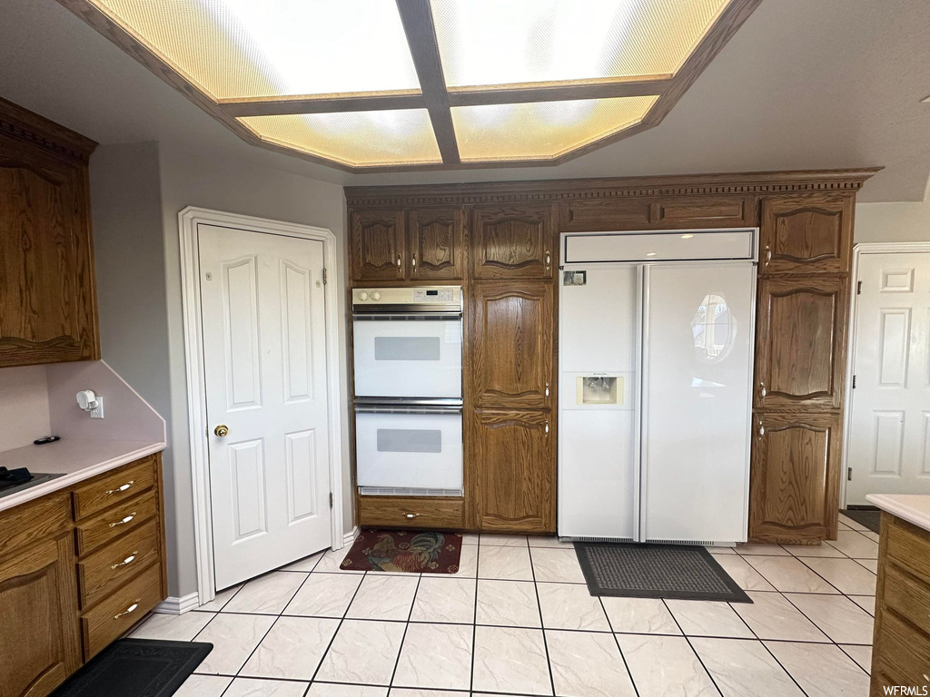 Kitchen with white appliances and light tile floors