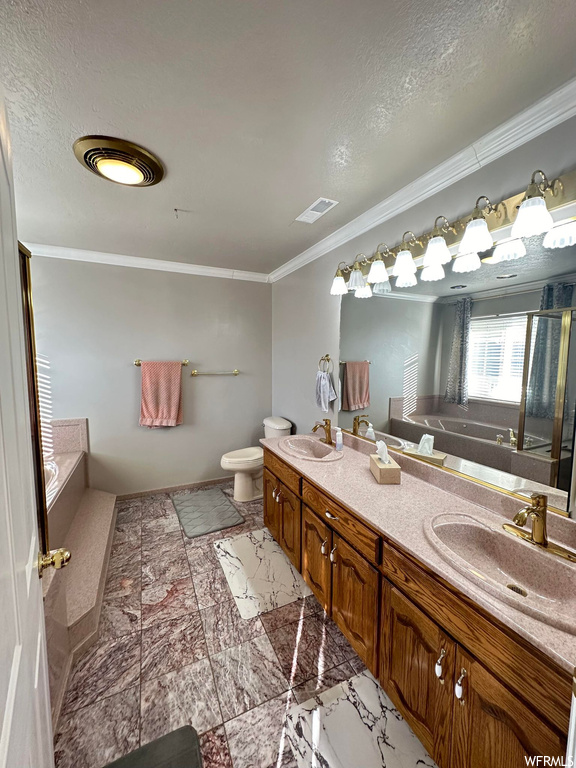 Bathroom with toilet, a tub, ornamental molding, tile floors, and dual vanity