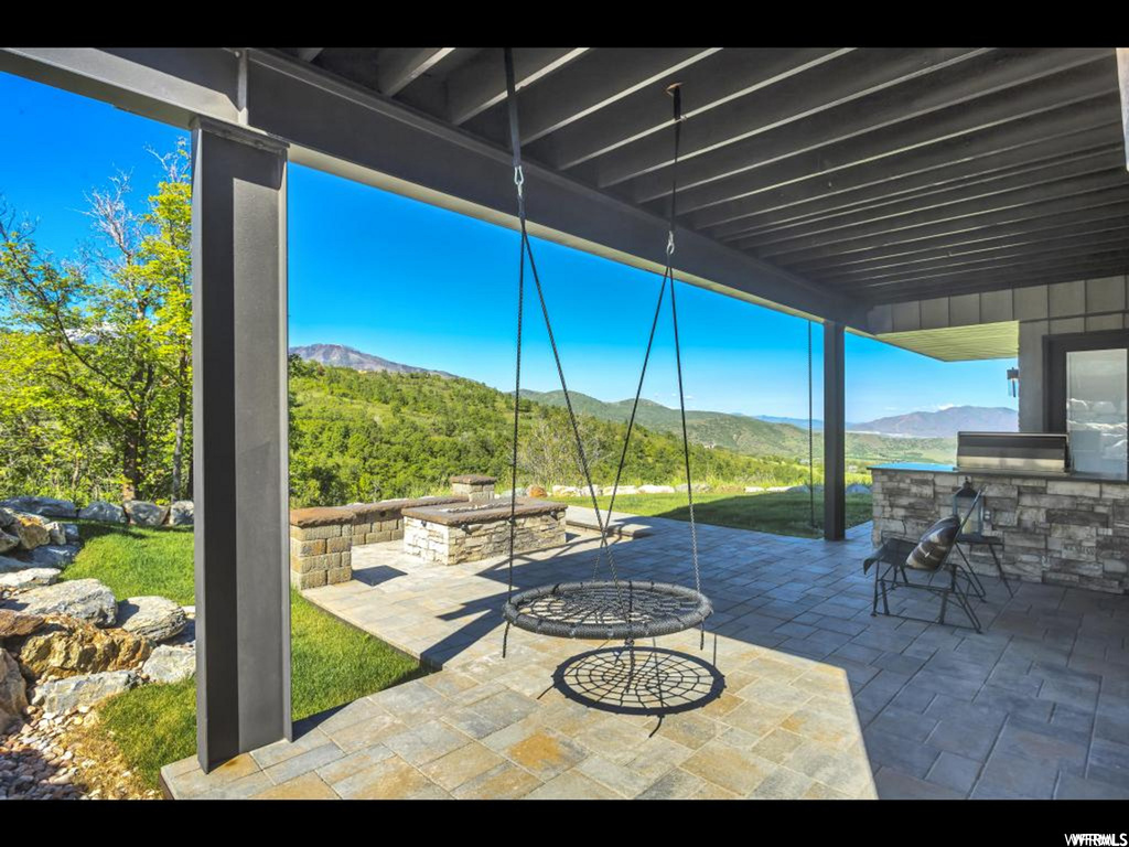 View of terrace featuring an outdoor fire pit and a mountain view