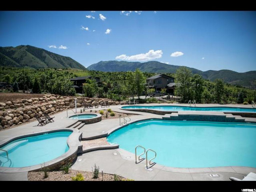View of swimming pool with a hot tub and a mountain view
