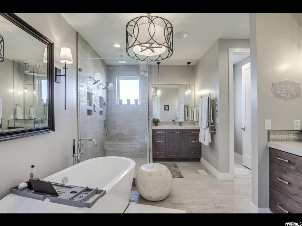 Bathroom with independent shower and bath, tile floors, and vanity