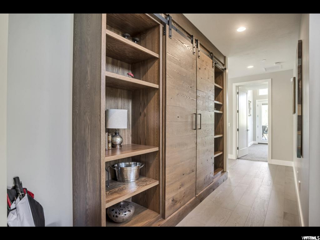 Hallway featuring a barn door and light hardwood / wood-style floors