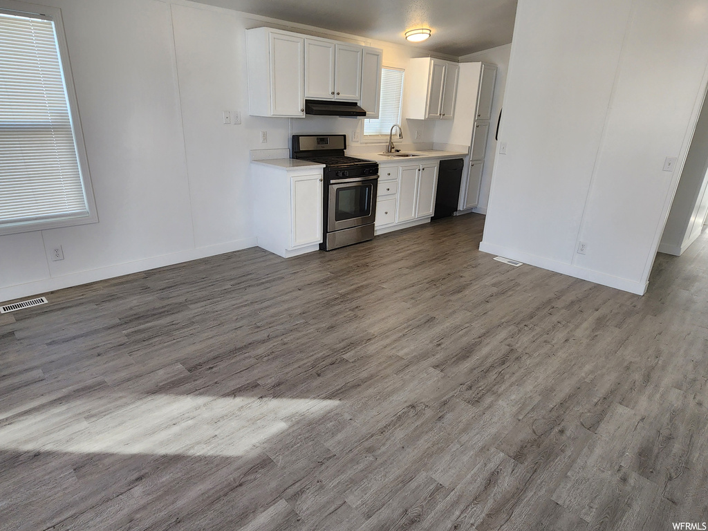 Kitchen featuring hardwood / wood-style floors, white cabinetry, and stainless steel gas range