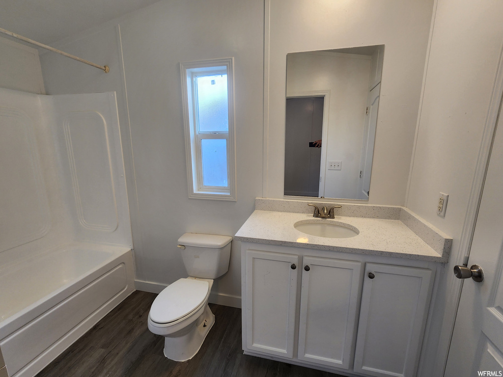 Full bathroom with vanity, toilet, shower / bathing tub combination, and hardwood / wood-style flooring