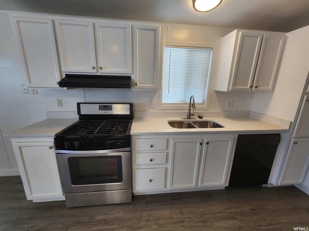 Kitchen featuring sink, black dishwasher, white cabinets, dark hardwood / wood-style flooring, and stainless steel range with gas stovetop