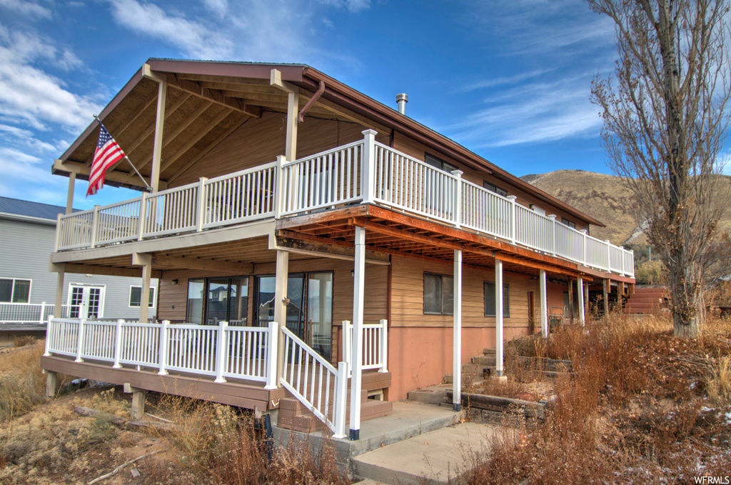View of front of home with a deck with mountain view