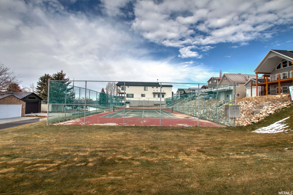View of home's community featuring a yard and tennis court