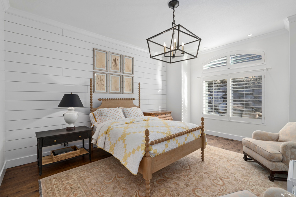 Bedroom featuring a notable chandelier, dark wood-type flooring, and crown molding