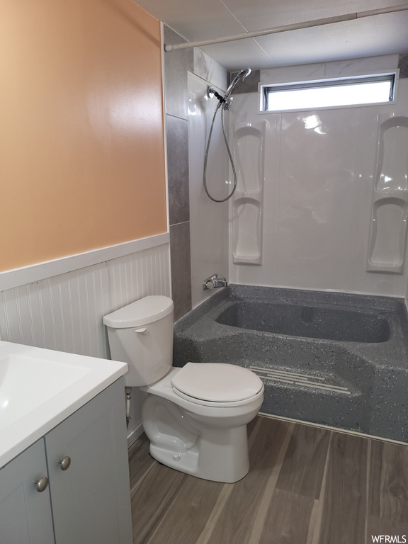 Full bathroom with toilet,  shower combination, vanity, and wood-type flooring