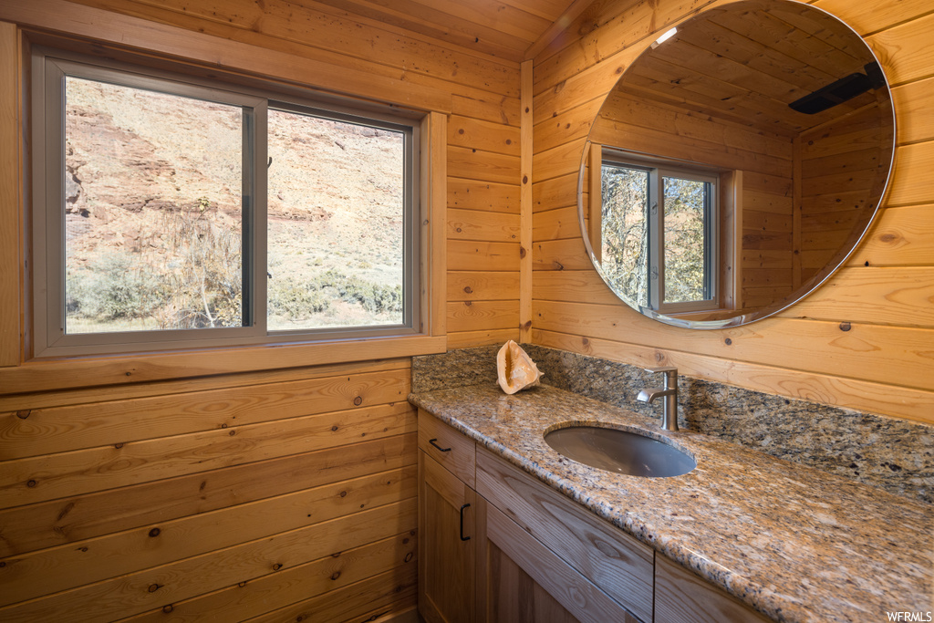 Bathroom with a healthy amount of sunlight, wood ceiling, and vanity