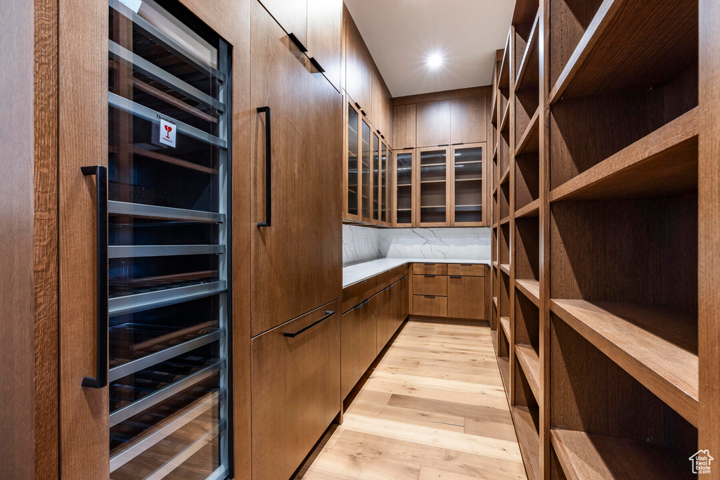 Spacious closet with beverage cooler and light wood-type flooring
