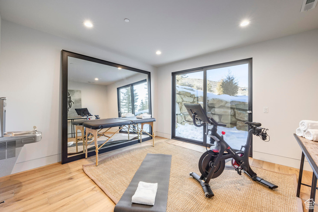 Workout area with light hardwood / wood-style floors