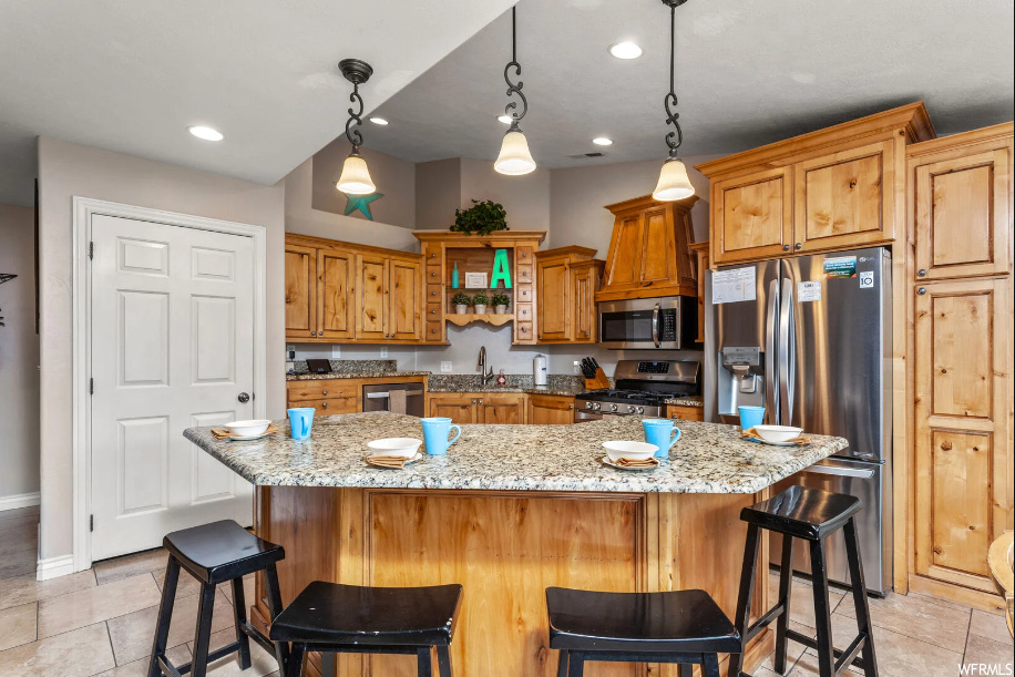 Kitchen featuring pendant lighting, a kitchen bar, and a center island