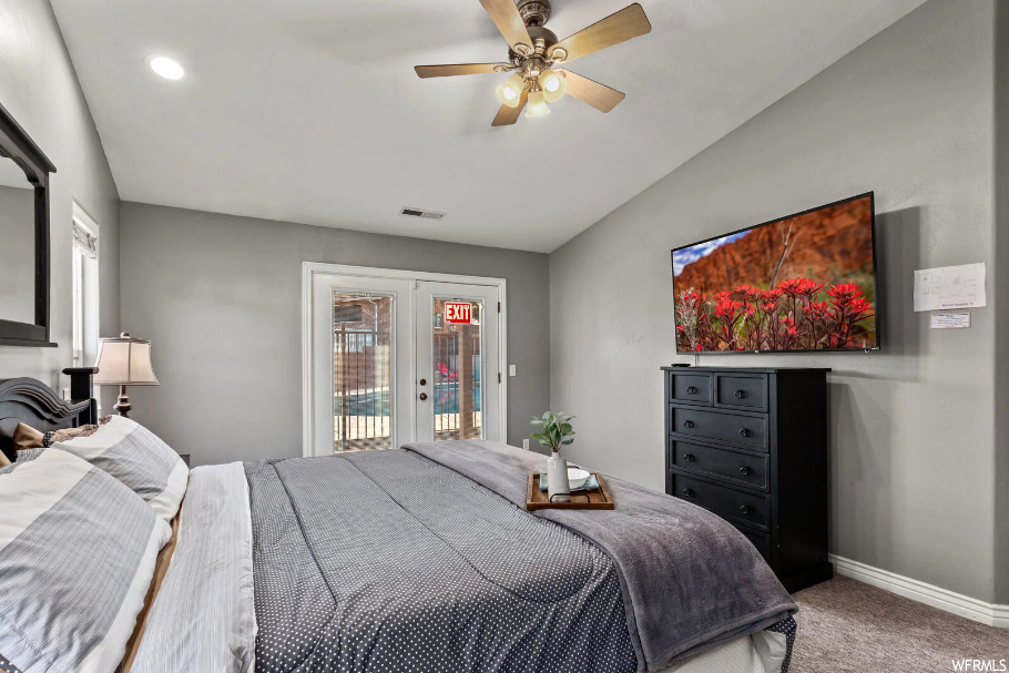 Carpeted bedroom featuring access to outside, ceiling fan, multiple windows, and french doors