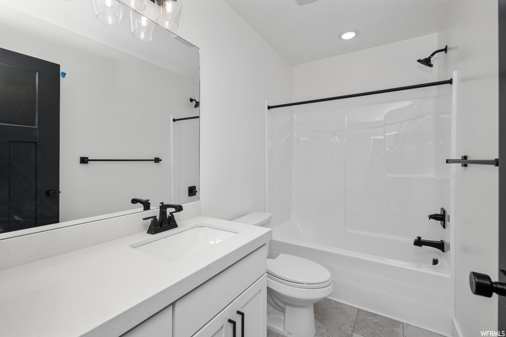 Full bathroom with toilet, bathtub / shower combination, tile floors, and oversized vanity