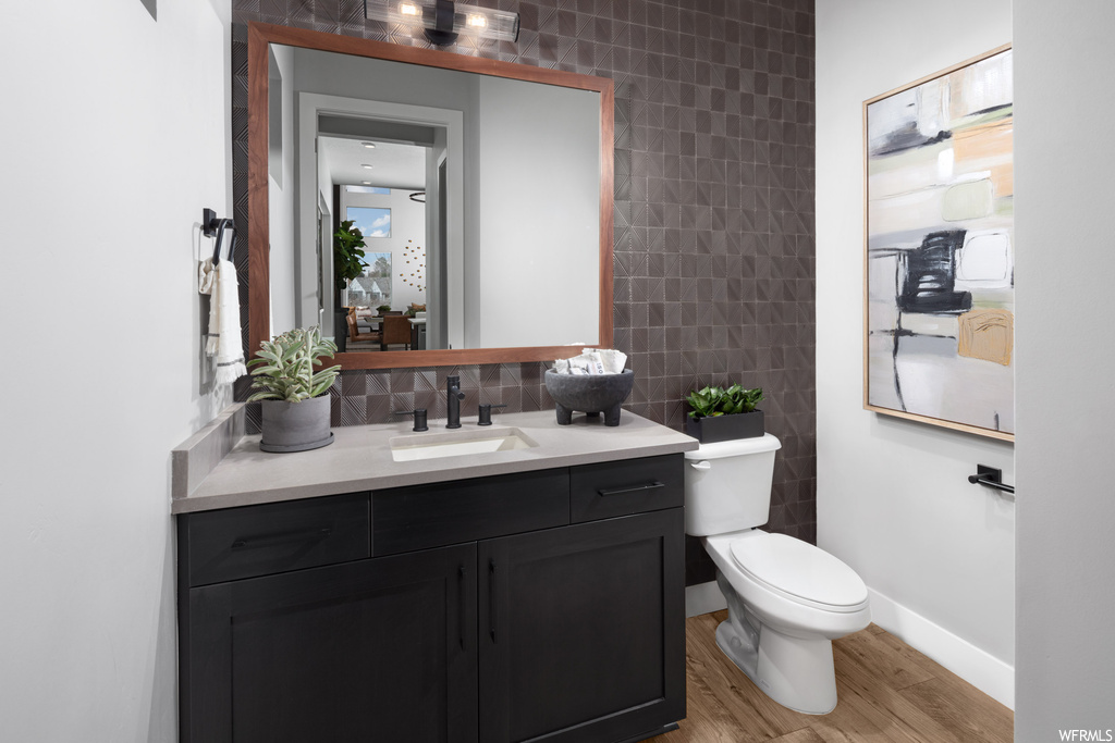 Bathroom featuring vanity, tile walls, tasteful backsplash, toilet, and wood-type flooring