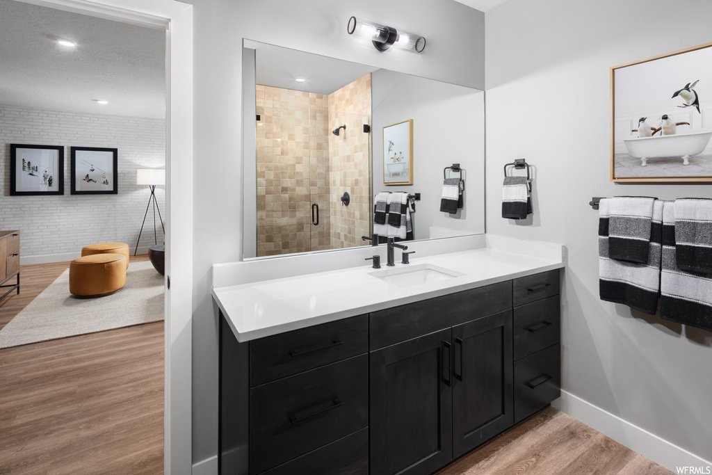 Bathroom with vanity, an enclosed shower, and hardwood / wood-style floors