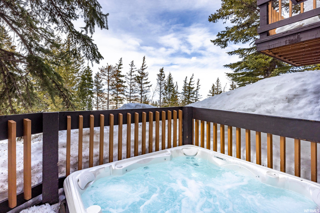 Snow covered deck with a hot tub