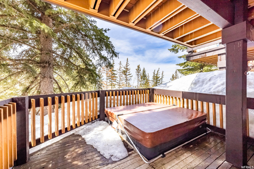Snow covered deck with a covered hot tub
