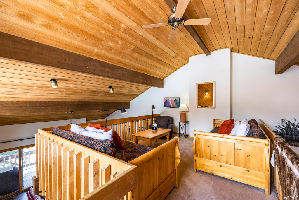 Bedroom featuring access to outside, wood ceiling, dark colored carpet, ceiling fan, and vaulted ceiling with beams