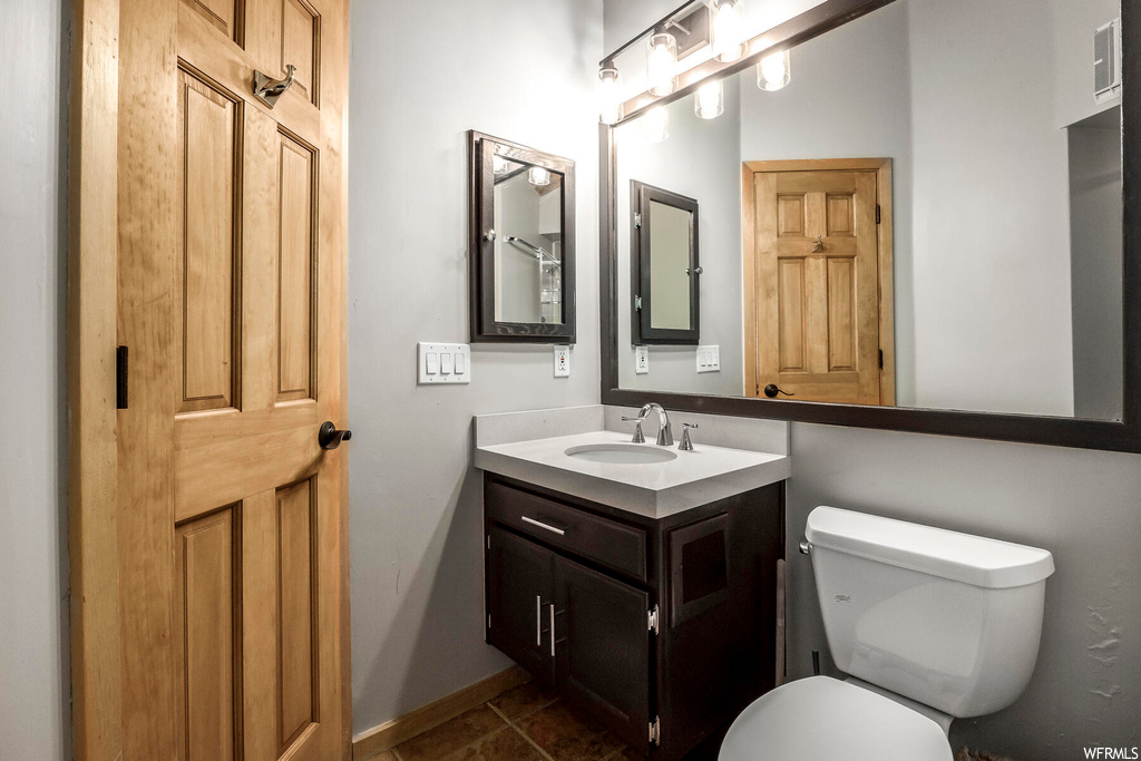 Bathroom featuring toilet, tile floors, and oversized vanity