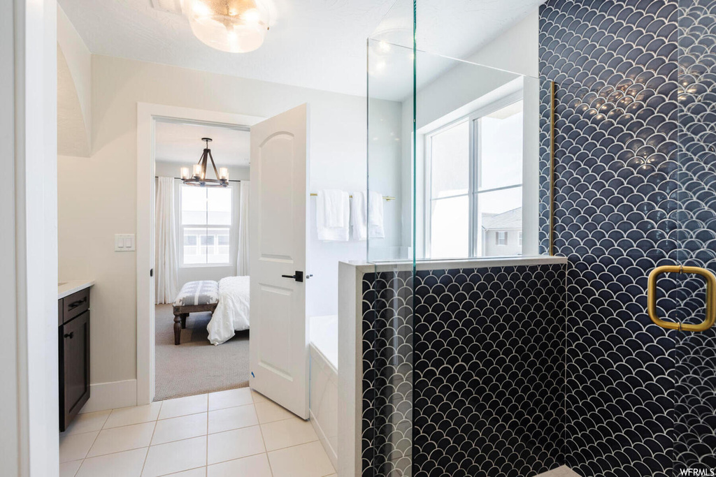 Bathroom with vanity, an inviting chandelier, and tile flooring