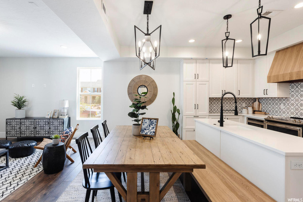 Dining area featuring hardwood / wood-style flooring, sink, and a notable chandelier