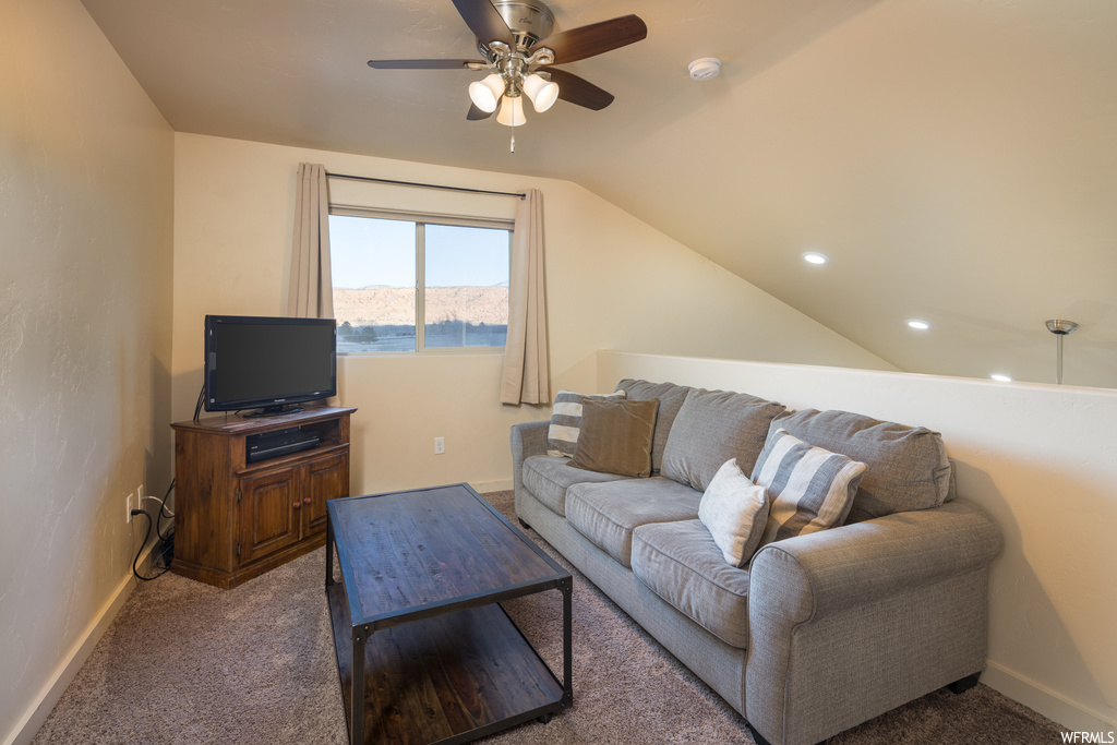Carpeted living room featuring ceiling fan, a mountain view, and vaulted ceiling