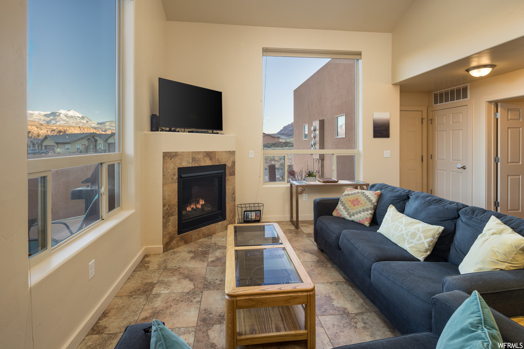 Tiled living room featuring a tiled fireplace and a mountain view