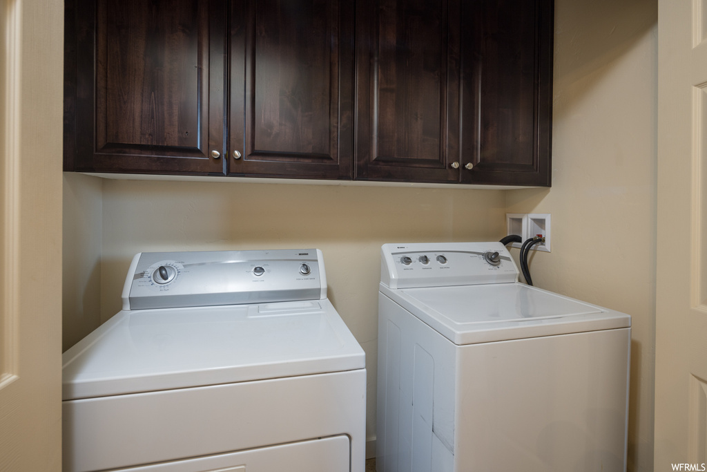 Laundry room featuring cabinets, washing machine and clothes dryer, and hookup for a washing machine