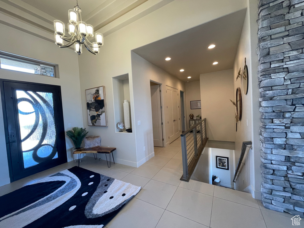 Entryway featuring light tile flooring and a chandelier