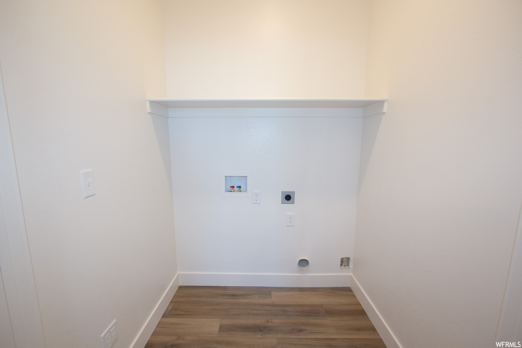 Clothes washing area with electric dryer hookup, dark hardwood / wood-style flooring, and hookup for a washing machine