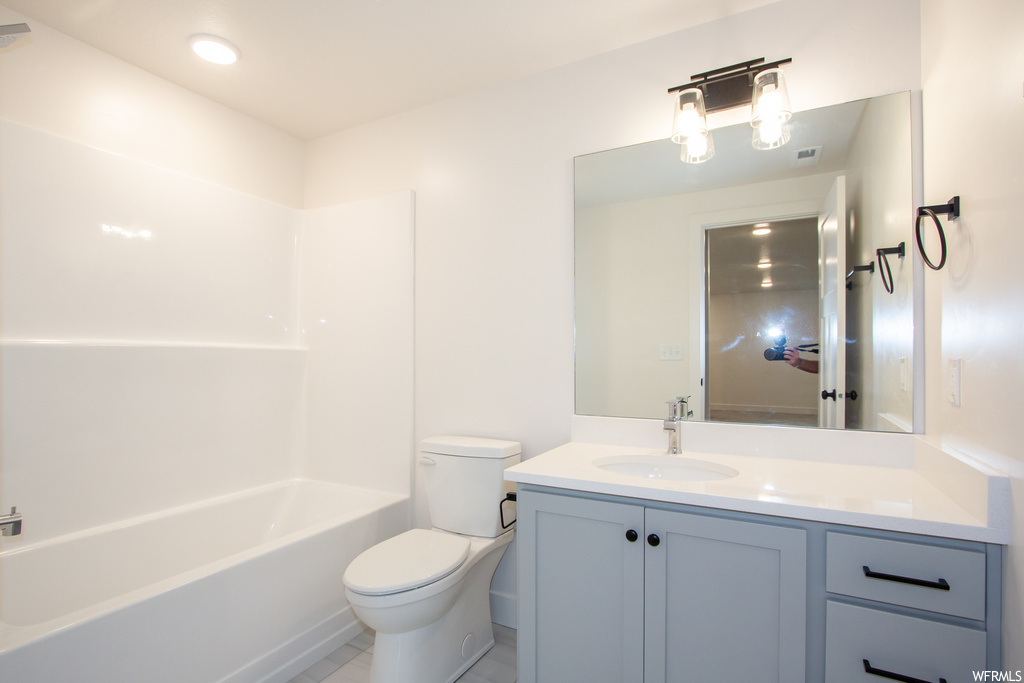 Full bathroom with toilet, tile flooring, shower / washtub combination, and vanity