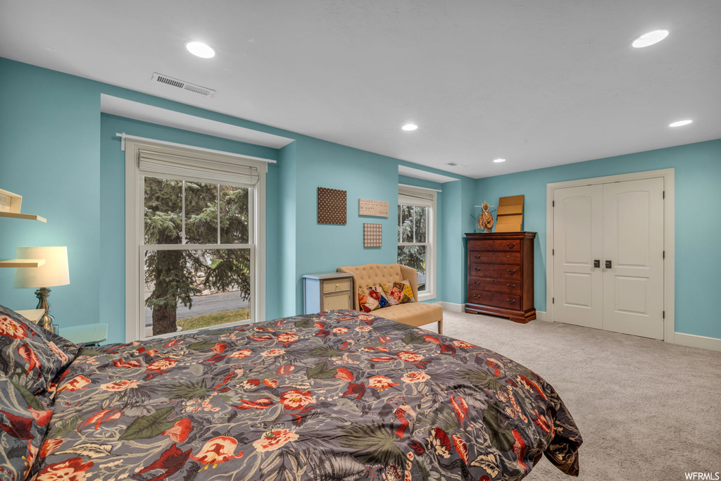 Bedroom with multiple windows and light colored carpet