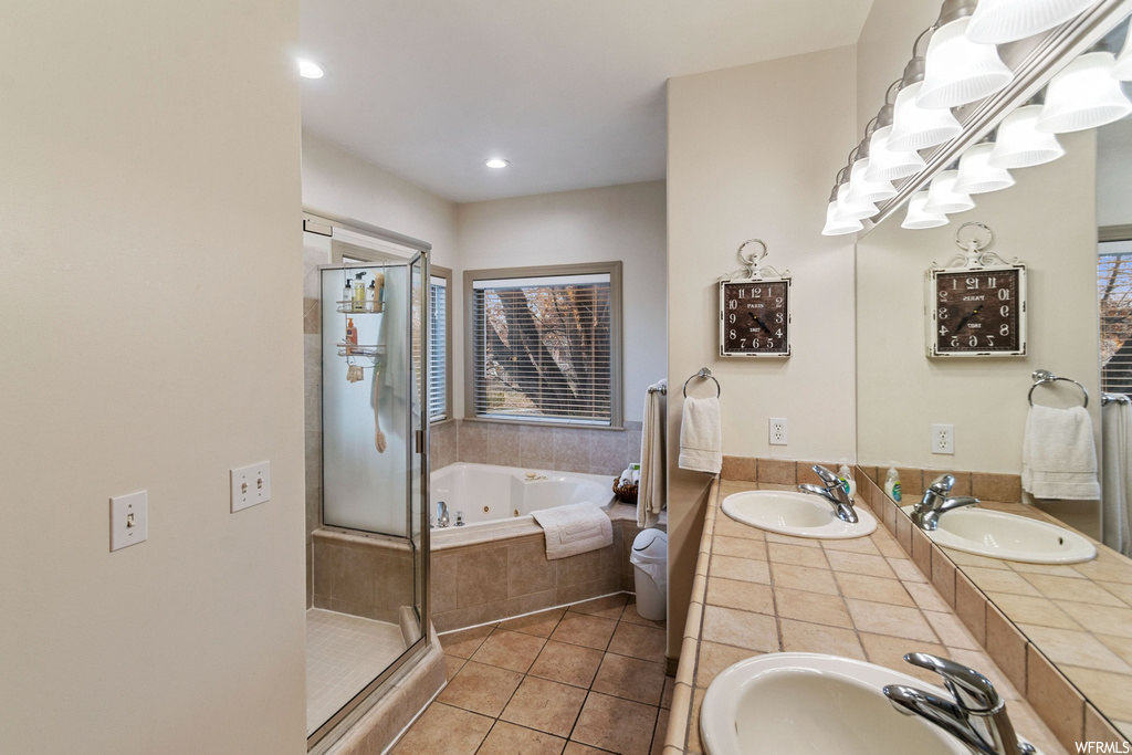 Bathroom featuring tile floors, plus walk in shower, and dual vanity