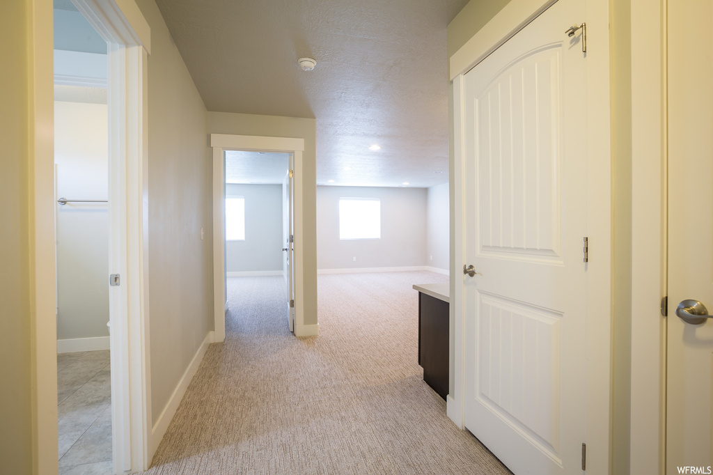 Hallway featuring light tile flooring
