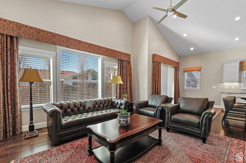 Living room featuring ceiling fan, high vaulted ceiling, and dark wood-type flooring