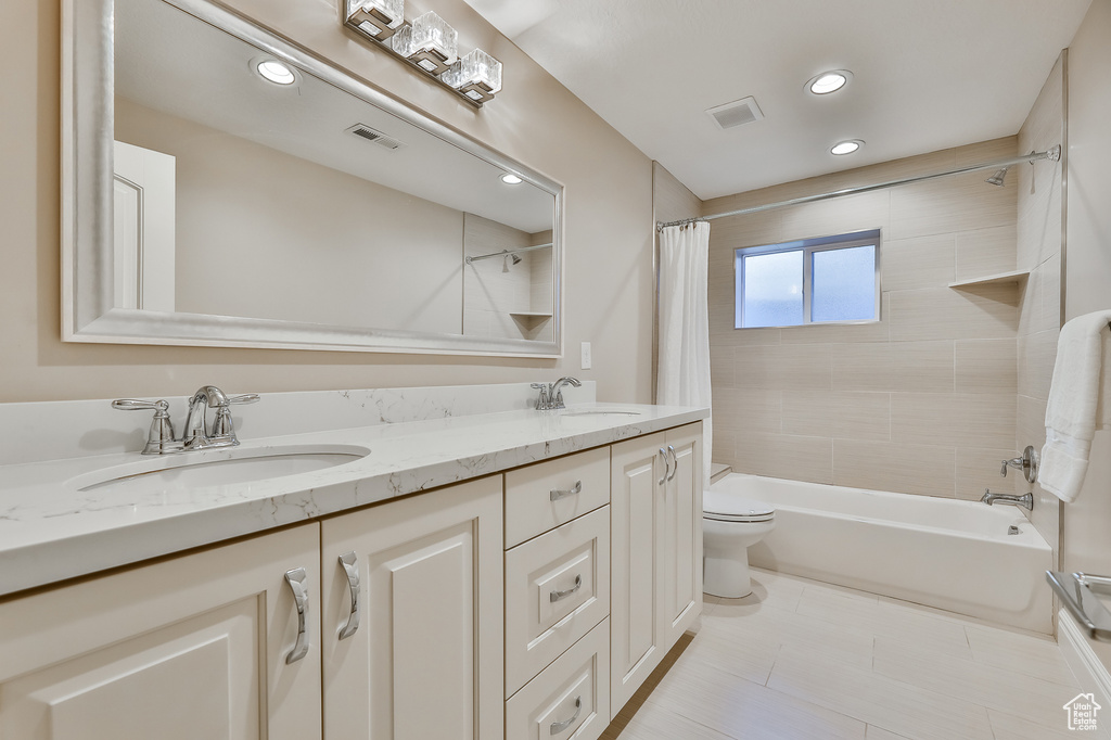 Full bathroom with double vanity, shower / tub combo, toilet, and tile floors