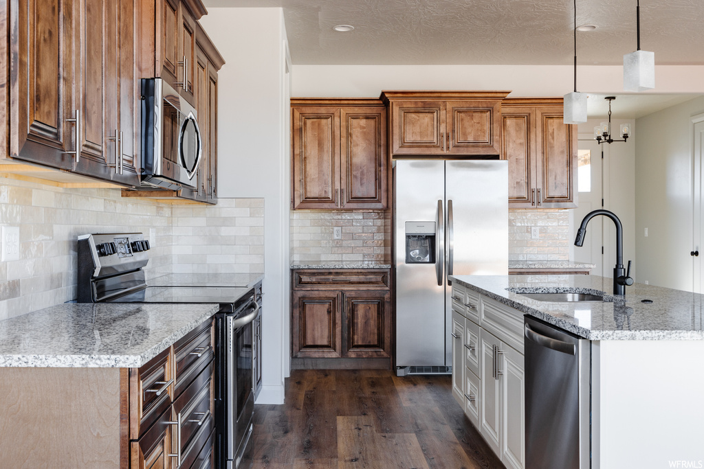 Kitchen featuring sink, dark hardwood / wood-style flooring, stainless steel appliances, and backsplash