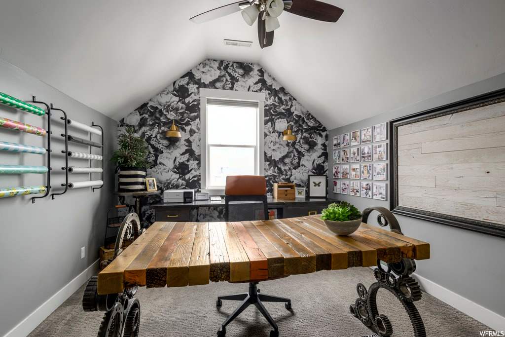 Home office featuring vaulted ceiling, carpet, and ceiling fan