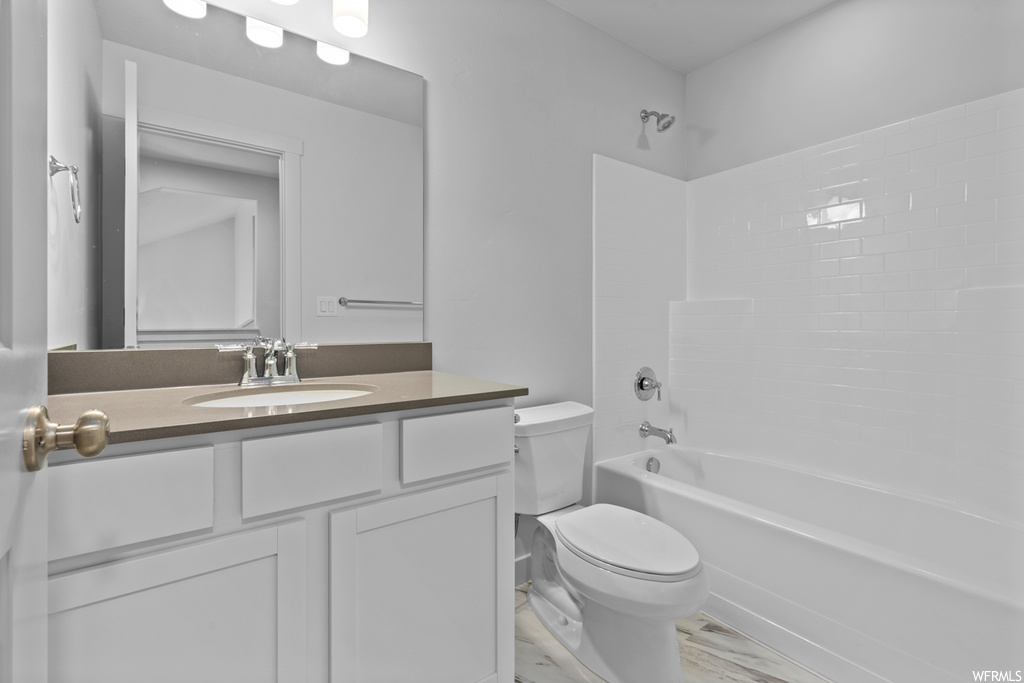 Full bathroom featuring toilet, hardwood / wood-style floors, bathtub / shower combination, and vanity