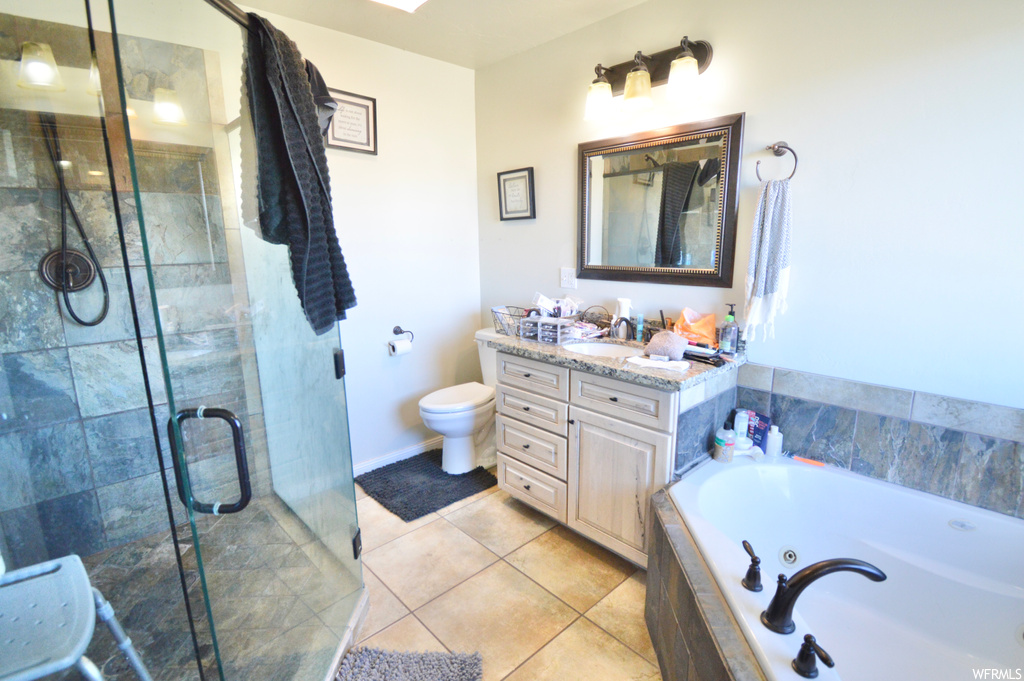 Full bathroom featuring separate shower and tub, vanity, toilet, and tile floors
