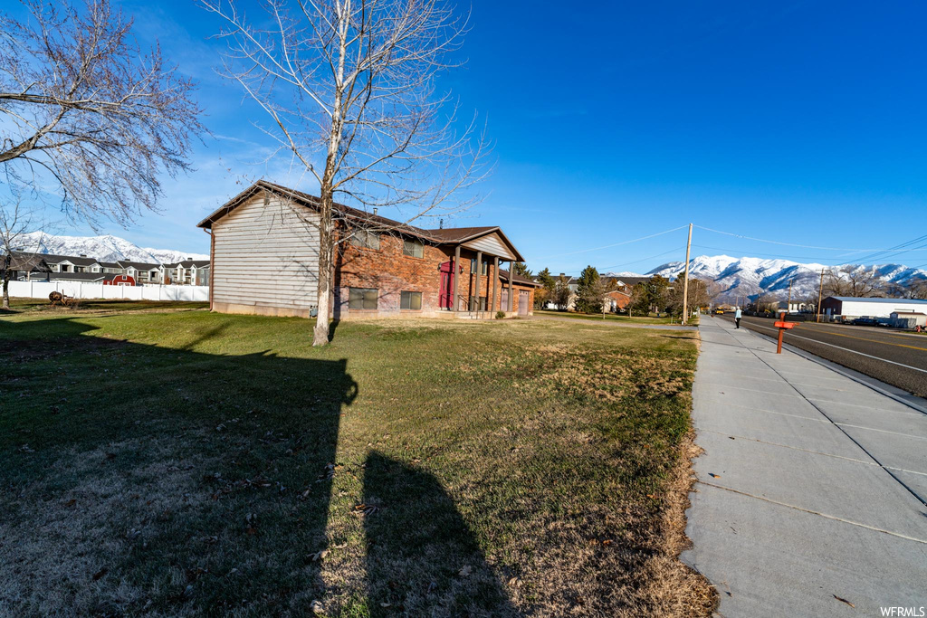 View of side of property featuring a yard and a mountain view