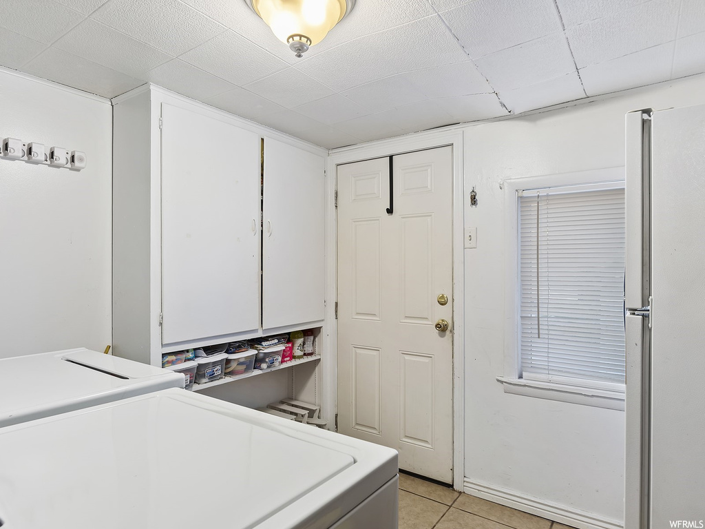 Laundry room with washer / dryer and light tile floors