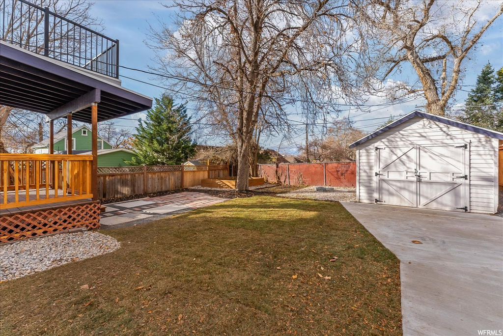 View of yard with a patio area, a storage shed, and a wooden deck
