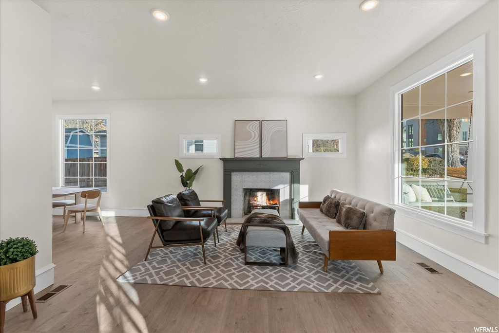 Living room featuring a tile fireplace and light hardwood / wood-style floors